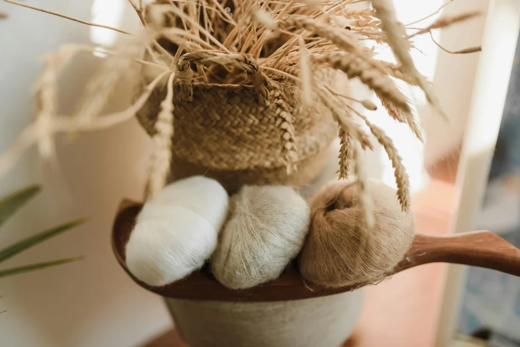 Close-up of natural cotton and jute yarn balls styled in a rustic home decor setting.